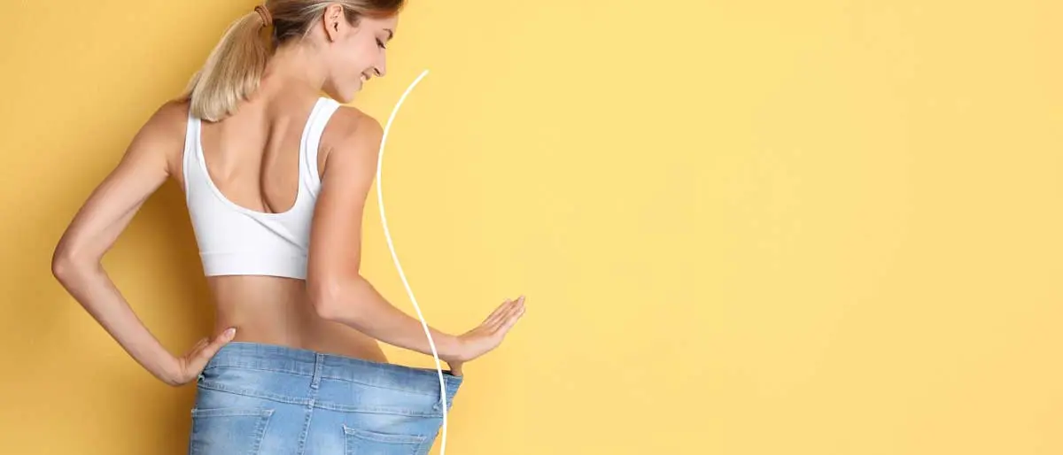 Mujer midiéndose la cintura con una cinta métrica